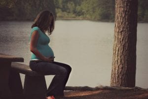 Pregnant woman sitting on picnic table
