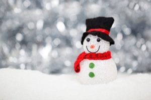 a smiling snowman wearing a red scarf and a black hat