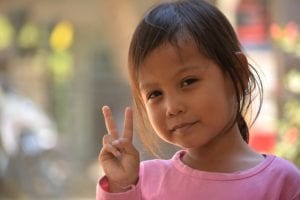 Young girl making v sign with her hand