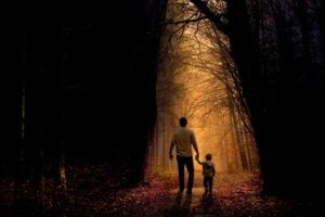 Father walking through woods with son