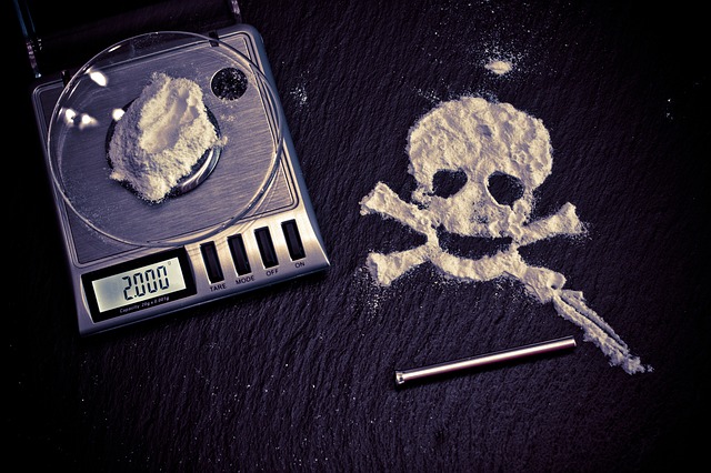 Drugs on scale and skull in crossbones made out of drugs