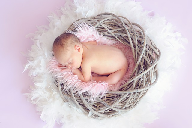 A baby sleeping curled up in a nest surrounded by feathers, symbolizing an infant who'se medical needs were neglected, resulting in their death.
