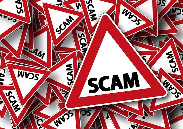 A pile of warning signs with the word 'scam' on them, inside a red triangle.
