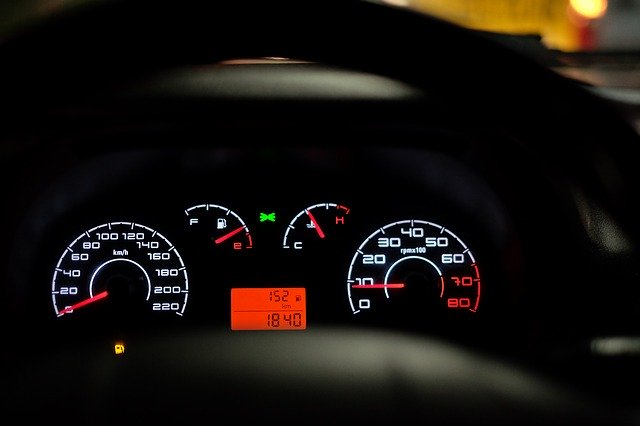 A close up of the driver's view of an instrument panel in the car, showing a speedometer and an odometer.