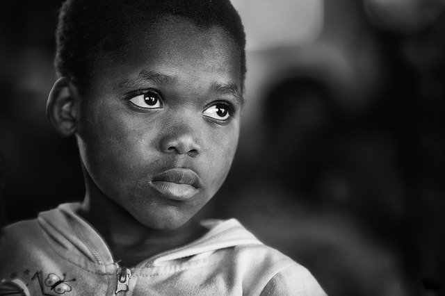 A black and white photo of a young African boy. Although people think of poverty as something that happens in the third world, it's right here too.