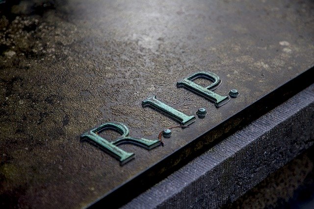A close up of the initials "R I P" on a grave.
