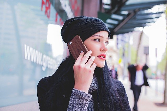 A young woman looking worried and making a phone call.