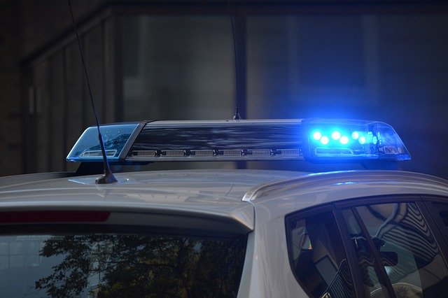 A close up of the top of a police car with the lights flashing